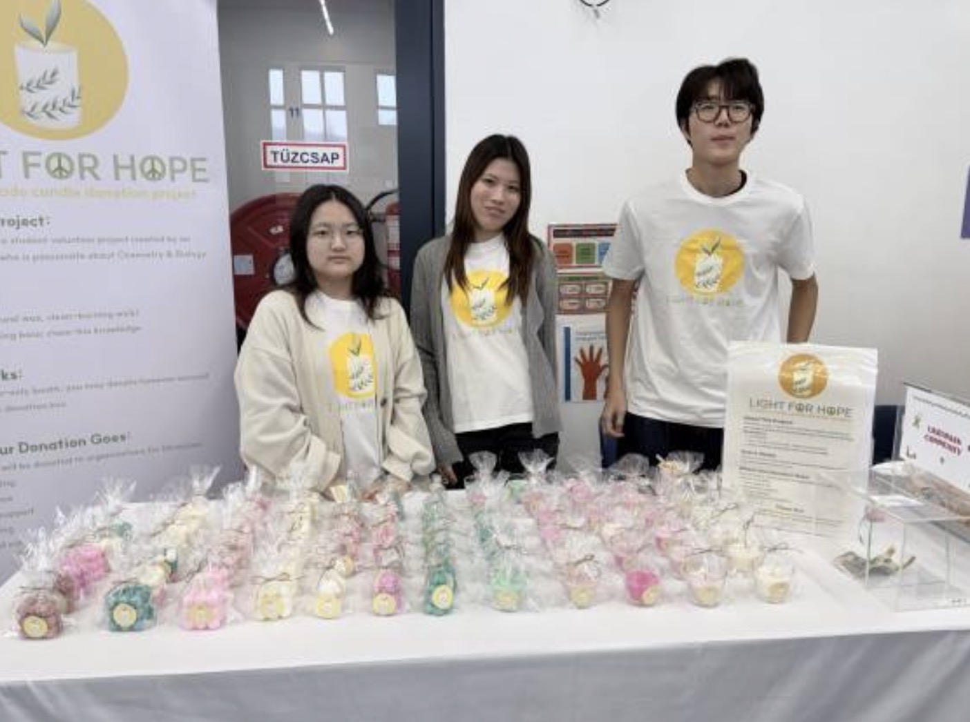 Hyunjin with Light for Hope campaign volunteers and handmade campaign goods